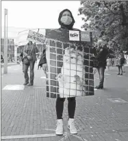  ??  ?? Un manifestan­te sostiene una imagen de un visón durante una protesta pidiendo el fin del comercio de sus pieles, en La Haya