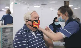  ?? EPA ?? Robert Williams, 84, receives an dose of a Covid-19 inoculatio­n at a mass vaccinatio­n centre in Stevenage, southern England, that opened on Monday