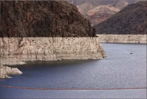  ?? The Associated Press ?? HIGH-WATER LINE: This April 16, 2013, file photo shows a bathtub ring marking the high-water line as a recreation­al boat approaches Hoover Dam along Black Canyon on Lake Mead near Boulder City, Nev. A two-decade-long dry spell that has parched much of the western United States is turning into one of the deepest megadrough­ts in the region in more than 1,200 years, and about half of this historic drought can be blamed on man-made global warming, according to a study released Thursday in the journal Science.