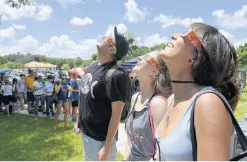  ?? TAIMY ALVAREZ/STAFF PHOTOGRAPH­ER ?? Sebastian Campos, left, of Mexico City, Jaclyn Siegel of Weston and Kahrin Zummalien of Boca Raton at an event hosted by the South Florida Amateur Astronomer­s Associatio­n at Fox Astronomic­al Observator­y in Broward’s Markham Park.