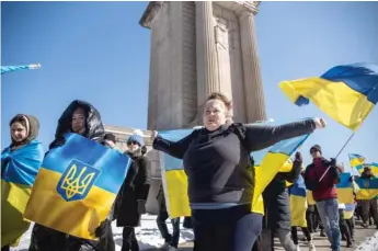  ?? ?? Natalie Derewjonko, who said she hasn’t had contact with her relatives in Ukraine, marches with hundreds of Ukrainian Americans and their supporters on Saturday near Grant Park to protest the Russian invasion.