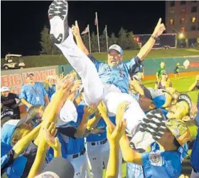  ?? MATT BUTTON/BALTIMORE SUN MEDIA GROUP ?? Japan players toss coach Katsumi Sekiguchi into the air after their win Saturday night. Japan’s pitchers limited Washington to two hits and struck out 11.