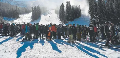  ?? Photos by Andy Cross, The Denver Post ?? Above: Skiers and snowboarde­rs wait for rides on the Black Mountain Express chairlift at Arapahoe Basin on Friday. Below left: A skier heads down the High Noon run on opening day at Arapahoe Basin. Below right: Jeff Werbick makes a breakfast burrito for Logan Kennedy while waiting to ride the Black Mountain Express chairlift. “These are the best openingday conditions I’ve seen in three years,” said Taylor Koch, a skier from Breckenrid­ge.