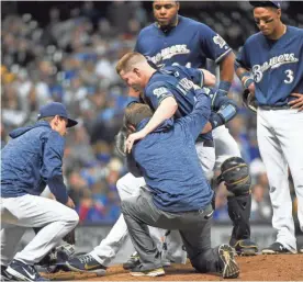  ?? BENNY SIEU / USA TODAY SPORTS ?? Brewers pitcher Corey Knebel is helped off the mound after suffering a hamstring injury in the ninth inning Thursday.