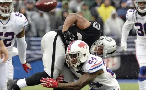  ??  ?? Oakland Raiders running back DeAndre Washington (33) fumbles the ball as he is hit by Buffalo Bills defensive back Leonard Johnson (24) during the first half of an NFL football game in Orchard Park, N.J. on Sunday. AP/ADRIAN KRAUS PHOTOS