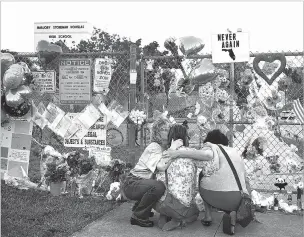  ??  ?? People gather last year at a memorial at Marjory Stoneman Douglas High School in Parkland, Fla., after a shooting on campus left 17 people dead. The school district said last month it would install a camera-software system called Avigilon that would allow security officials to flag students based on their appearance.