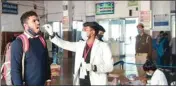  ?? ?? A medical worker collects swab sample of a passenger for Covid-19 test at Charbagh railway station in Lucknow, on Friday