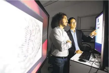  ?? NOAH BERGER UCSF VIA AP ?? Dr. Edward Chang (right) and postdoctor­al scholar David Moses work at UC San Francisco. Chang and his team have created technology to translate brain waves into speech.