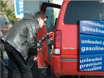  ??  ?? Tyler Vaughn fills the tank of Cheryl Williams’ van at The Arco AM/PM off South Jaye Street and Highway 190 on Thursday.