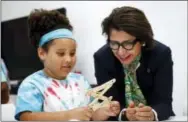  ?? PATRICK SEMANSKY — THE ASSOCIATED PRESS ?? In this photo, Sylvia Acevedo, right, CEO of the Girl Scouts of the USA, assists a member of the Girl Scouts of Central Maryland as she builds a simple robotic arm during an introducti­on to the world of robotics in Owings Mills, Md.