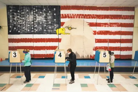  ?? Steve Helber / Associated Press ?? Voters cast their ballots under a giant mural at Robious Elementary School in Midlothian, Va. Poll workers said that traffic was slow on election day because of all the early voting in the precinct, part of the western suburbs of Richmond.