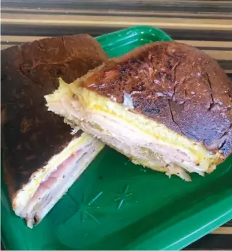  ??  ?? The Miami Cuban sandwich is made of ham, porchetta, swiss cheese, pickles, and mustard on homemade cuban bread and it is grilled.