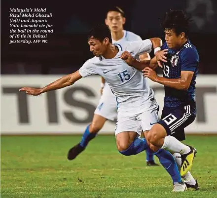  ?? AFP PIC ?? Malaysia’s Mohd Rizal Mohd Ghazali (left) and Japan’s Yuto Iwasaki vie for the ball in the round of 16 tie in Bekasi yesterday.