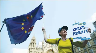  ?? (Hannah McKay/Reuters) ?? AN ANTI-BREXIT PROTESTER waves EU and Union Jack flags and holds up a placard opposite the Houses of Parliament in London last week.