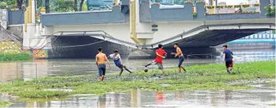 ?? ANGGER BONDAN/JAWA POS ?? AKSI PROTES: Lima mahasiswa yang tergabung dalam Muhammadiy­ah for Maritim Indonesia bermain sepak bola di Kalimas.