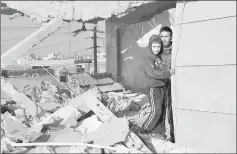  ??  ?? Civilians stand in a damaged house after an airstrike in the rebel-held southern town of Bosra al-Sham, Deraa Governorat­e, Syria. — Reuters photo