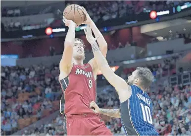  ?? MICHAEL LAUGHLIN/STAFF PHOTOGRAPH­ER ?? Miami’s Kelly Olynyk, who had 15 points and 11 rebounds Tuesday night, shoots over Orlando’s Evan Fournier during the first half.