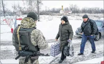  ?? AP PHOTO ?? Ukrainians cross the border from Russia to Ukrainian side of the Ukraine-Russia border in Milove town, eastern Ukraine, Sunday.