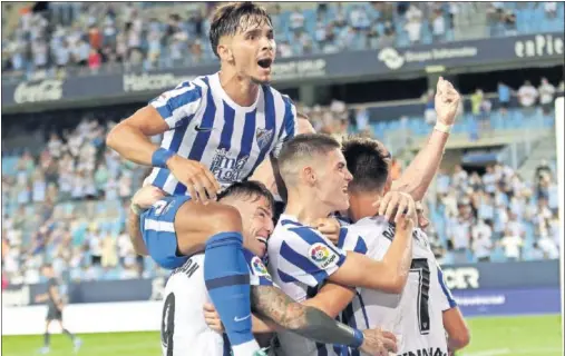  ??  ?? Los jugadores del Málaga celebran eufóricos su primer gol al Girona, obra de Paulino.
