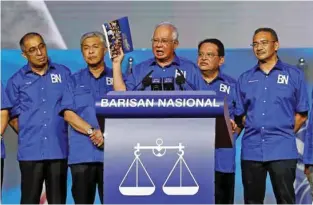  ?? — REUTERS/Lai Seng Sin ?? WOOING VOTERS: Malaysia’s Prime Minister and president of ruling party National Front, Najib Razak holds up a booklet on his party’s manifesto during its launch for upcoming general elections in Kuala Lumpur, Malaysia April 7, 2018.