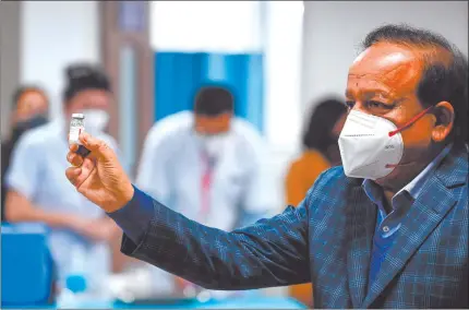  ?? Nampa/AFP ?? Lifesaving… India’s Health Minister Harsh Vardhan displays a vial of a Covid-19 coronaviru­s vaccine at the All India Institute of Medical Science in New Delhi on Saturday.