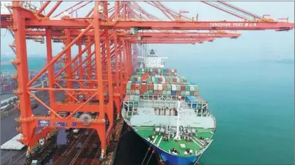  ?? YANG SHIYAO / XINHUA ?? A ship loads cargo at Jingtang Port’s container terminal in Tangshan, Hebei province.