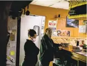  ??  ?? Owner Shimeles Kibret works behind the counter with his wife Yetanyet Kibret fielding takeout orders at Red Sea Ethiopian Restaurant in City Heights.