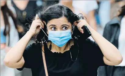  ?? TOLGA AKMEN / AFP ?? Una mujer se ajusta la mascarilla en una calle comercial de Londres