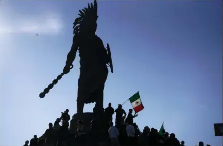  ?? RAMON ESPINOSA — THE ASSOCIATED PRESS ?? Demonstrat­ors stand under an indigenous statue of Aztec ruler Cuauhtemoc as they protest the presence Sunday of thousands of Central American migrants in Tijuana, Mexico. Protesters accused the migrants of being messy, ungrateful and a danger to Tijuana.
