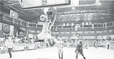  ??  ?? USJ-R's Nigerian import Tochukwu Eweneki slams the ball home during their CESAFI basketball match against UV last night at the Cebu Coliseum. USJ-R won, 89-73.