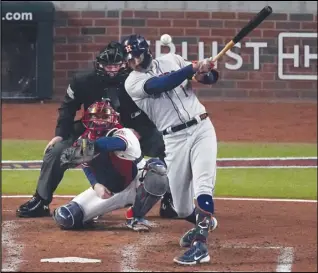  ?? Associated Press ?? The Houston Astros’ Carlos Correa hits an RBI-double during the third inning in Game 5 of the World Series against the Atlanta Braves on Sunday in Atlanta. Correa had three hits and two RBIs in the Astros’ 9-5 victory to cut the Braves’ series lead to 3-2.