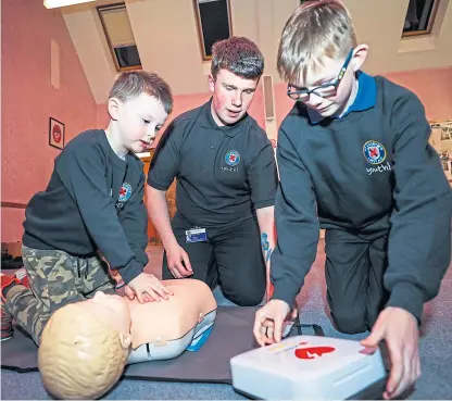  ?? Picture: Steven Brown. ?? Youngsters Tyrel and Finlay learn CPR with David Cook, middle.