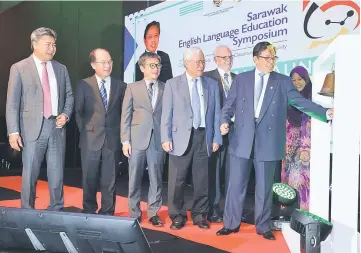  ??  ?? Abang Johari rings the bell to launch the symposium. Seen are Manyin (fourth left), Dr Annuar (third left) and Sudarsono (left). — Photo by Chimon Upon