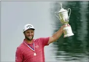  ?? JAE C. HONG — THE ASSOCIATED PRESS ?? Jon Rahm, of Spain, holds the champions trophy for photograph­ers after the final round of the U.S. Open Golf Championsh­ip, Sunday at Torrey Pines Golf Course in San Diego.
