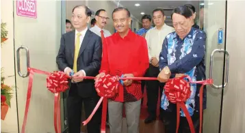  ??  ?? Razarudin (middle) cutting the ribbon with Eric (left) and Hassan (right) to mark the opening of the new Tronexus Sabah branch at Asia City on Saturday.