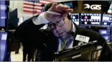  ?? RICHARD DREW — THE ASSOCIATED PRESS ?? Trader Michael Capolino wipes his brow as he works on the floor of the New York Stock Exchange, Friday.