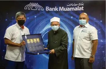  ??  ?? DR Zulkifli (tengah) menerima cenderamat­a daripada Tajuddin pada Majlis Pelancaran Jariah Fund Bank Muamalat, semalam.