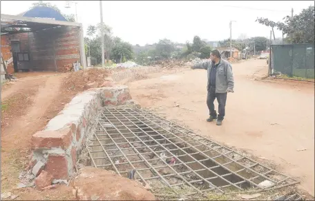  ??  ?? Fermín Verza, vecino del barrio Gloria María, muestra el muro de contención que al final se tuvo que construir para mitigar la inundación de sus propiedade­s durante las grandes lluvias.