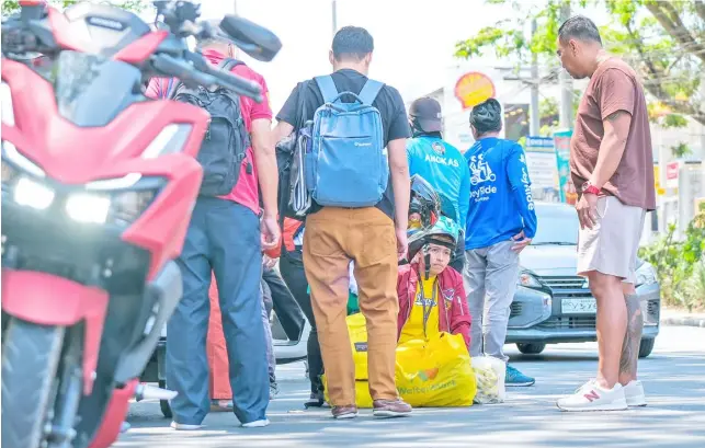  ?? PHOTOGRAPH BY KING RODRIGUEZ FOR THE DAILY TRIBUNE ?? A MOTORCYCLE rider is being attended to by passersby after she was hit by another vehicle in a road mishap in Silang, Cavite on Sunday.