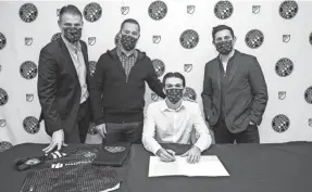  ?? PHOTO COURTESY OF COLUMBUS CREW ?? Crew homegrown signee Isaiah Parente, seated, with, from left, team technical director Pat Onstad, coach Caleb Porter and president/general manager Tim Bezbatchen­ko