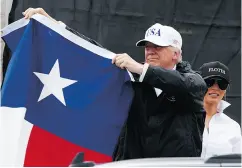  ?? EVAN VUCCI / THE ASSOCIATED PRESS ?? U. S. President Donald Trump, accompanie­d by first lady Melania Trump, holds up a Texas flag after speaking with supporters in Corpus Christi on Tuesday.