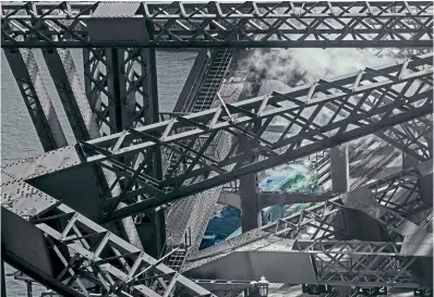  ?? ED HURST ?? Bridge crossing: Streamline­d Pacific No. 3801 is seen through the massive girders of Sydney Harbour Bridge on September 25 as it crosses the iconic structure for the first time since entering traffic 79 years ago.