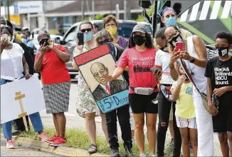  ?? CURTIS COMPTON / CCOMPTON@AJC.COM ?? Mourners gather Sunday for another historic moment with John Lewis in Selma, as the civil rights icon was symbolical­ly taken across the Edmund Pettus Bridge once more.