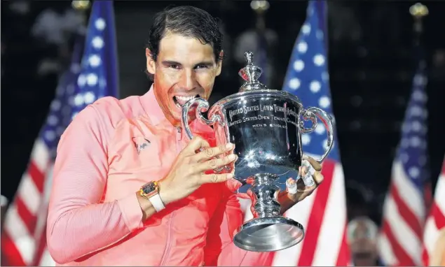  ??  ?? ÉXTASIS. Rafa Nadal muerde el trofeo en Nueva York después de conquistar su tercer título en la Gran Manzana y el 16º Grand Slam de su carrera.