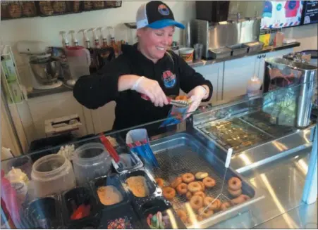  ?? DONNA ROVINS — DIGITAL FIRST MEDIA ?? DonutNV co-owner Amanda Gingold prepares an order of fresh mini doughnuts at DonutNV in Pottstown.