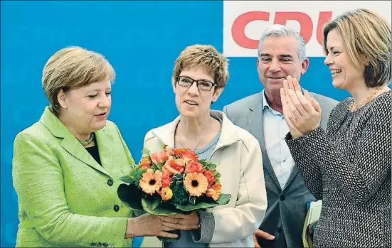  ?? JOHN MACDOUGALL / AFP ?? Angela Merkel entregando un ramo de flores a la presidenta reelecta de Sarre, Annegret Kramp-Karrenbaue­r, ayer en Berlín