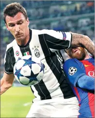  ?? ANTONIO CALANNI ASSOCIATED PRESS ?? Juventus striker Mario Mandzukic (left) fends off Barcelona's Lionel Messi to win possession during the first leg of their Champions League quarterfin­al at Juventus Stadium in Turin, Italy, on Tuesday. Juve won 3-0.