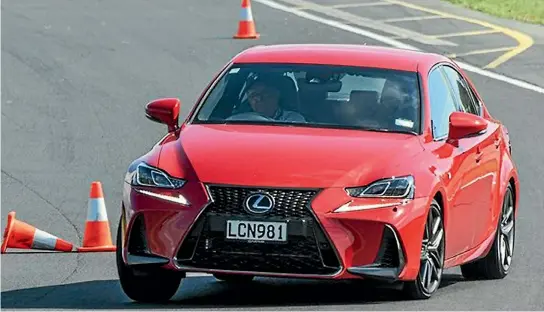  ??  ?? A Lexus IS350 F Sport leans on its front suspension as it takes on a slalom course.