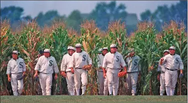  ?? Associated Press ?? Field of Dreams: Persons portraying ghost player characters, similar to those in the film "Field of Dreams," emerge from the cornfield at the "Field of Dreams" movie site in Dyersville, Iowa, in this undated file photo. Three decades after Kevin Costner's character built a ballpark in a cornfield in the movie "Field of Dreams," the iconic site in Dyersville, Iowa, prepares to host the state's first Major League Baseball game at a built-for-the-moment stadium for the Chicago White Sox and New York Yankees.