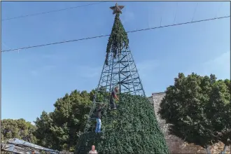  ?? ?? Palestinia­n workers prepare a Christmas tree on Nov. 16 in Manager Square adjacent to the Church of the Nativity.